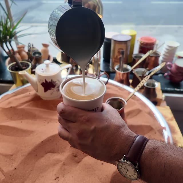 Pouring a latte at the sand station